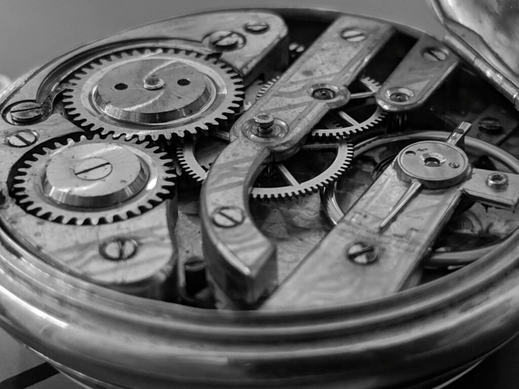 open timepiece exposing cogs and gear wheels open timepiece exposing cogs and gear wheels
