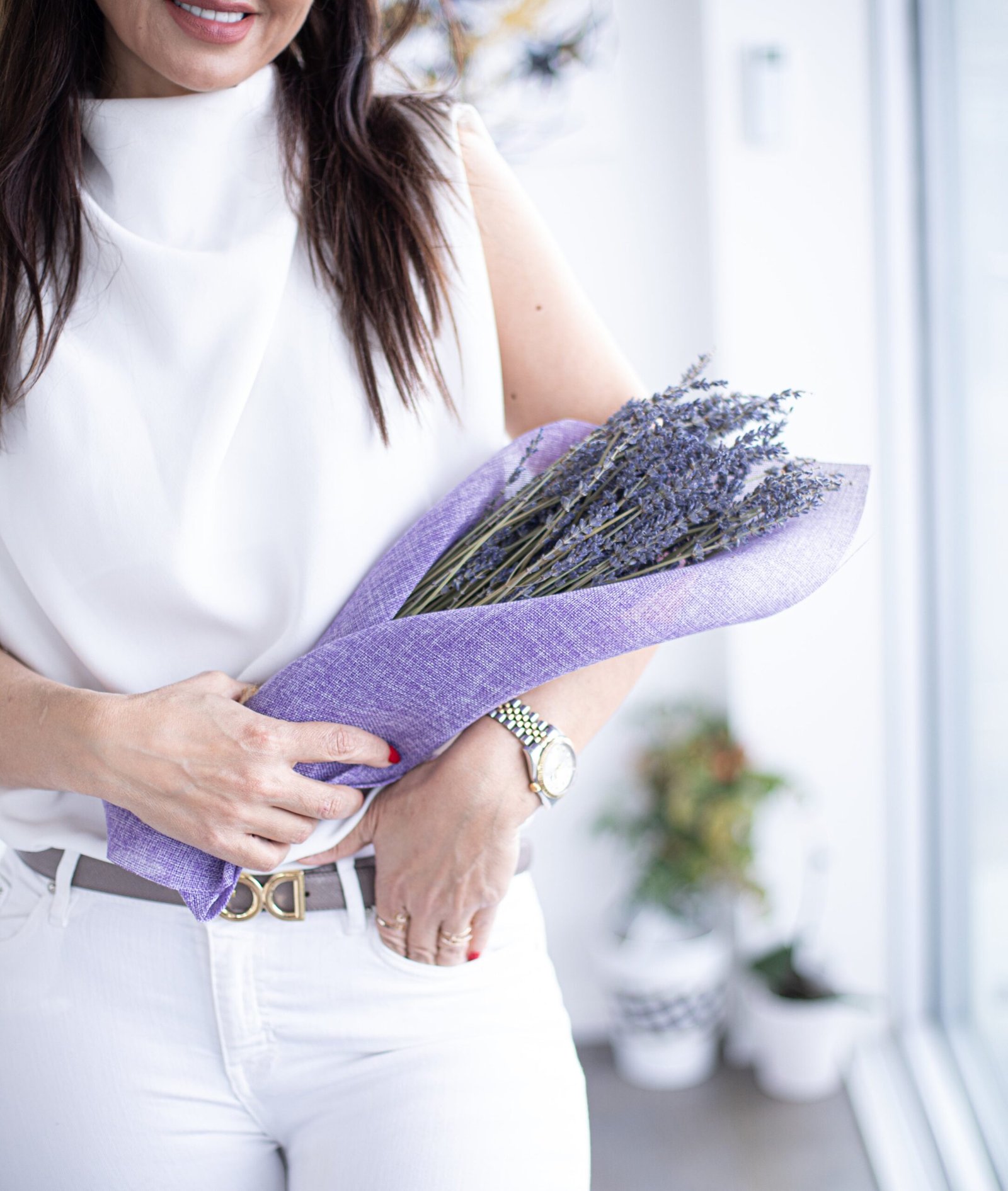 person holds a bundle of lavender wrapped in purple fabric person holds a bundle of lavender wrapped in purple fabric