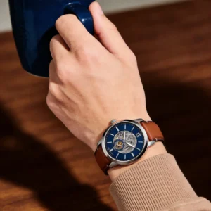 Man with watch holding coffee.