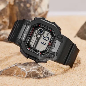 Black digital watch on sand